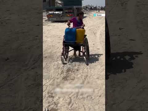 Palestinian boy struggles to drag water cart