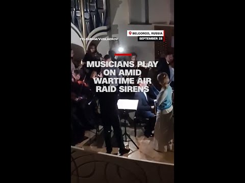 Musicians play on amid wartime air raid sirens