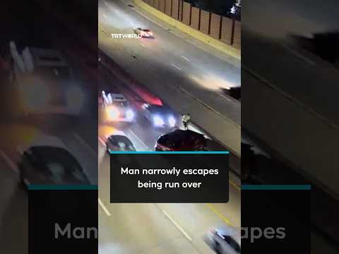 Man jumps onto highway barrier to avoid being hit